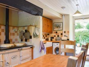 a kitchen with a sink and a stove top oven at Flood House in Bridport