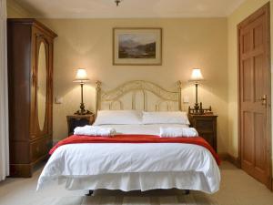 a bedroom with a large bed with two pillows on it at Rowan Cottage in Aviemore