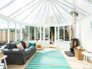 a conservatory with a couch and a glass roof at High Street in Kirkcudbright