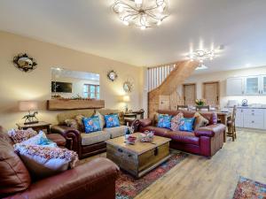 a living room with leather couches and a table at Farriers Lodge in Burshill