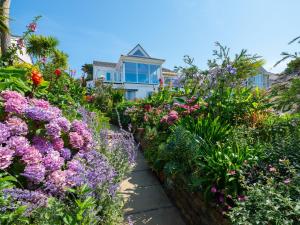 a garden of flowers in front of a house at Polgew Apartment in Marazion