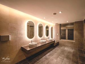 頭頓的住宿－Melon Home - The Sóng Apartment Vũng Tàu，浴室设有3个水槽和3面镜子