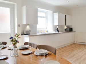 a kitchen and dining room with a table and chairs at Helena in Prestwick