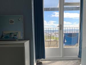 a room with a door open to a balcony with a view at Dolphin Cottage in Grange Over Sands