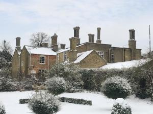an old brick house with chimneys in the snow at The Dower House 