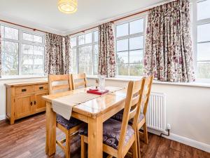 a dining room with a wooden table and chairs at White Oak Cottage in Ashby