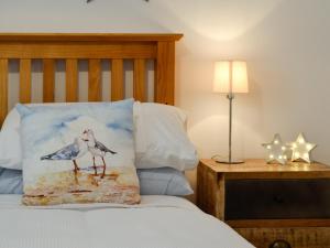 a bed with a pillow with two birds on it at Y Gweithdy in Barmouth