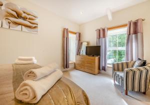 a bedroom with a bed and a tv and a couch at Gwynnant House in Rhyd Lewis