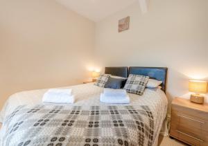 a bedroom with a bed and a dresser with a night stand at Gwynnant House in Rhyd Lewis