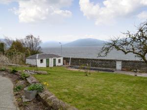 a house in a yard next to the water at Fircliff - The House On Bute in Port Bannatyne