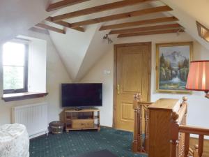 a living room with a flat screen tv and a tv stand at Cluniter Cottage in Innellan