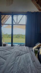 1 dormitorio con cama y ventana grande en Jairo's Nest, en Balasan