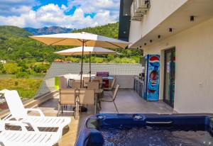 patio z basenem, krzesłami i parasolem w obiekcie Pensiunea Maya Caciulata w mieście Caciulata