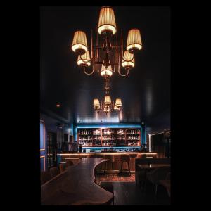 a room with a bar with a chandelier at Kings Hotel Egmore in Chennai