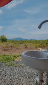 - un lavabo blanc installé sur le côté d'un champ dans l'établissement Jairo's Nest, à Balasan