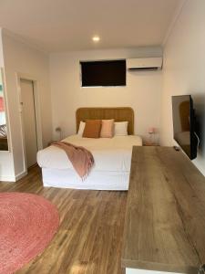 a bedroom with a bed and a flat screen tv at Harbour View Motel in Robe