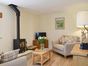 a living room with a wood stove and a couch at Tormire Laithe in Bell Busk