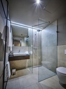 bagno con doccia, lavandino e servizi igienici di Hotel Der Einrichter a Straubing