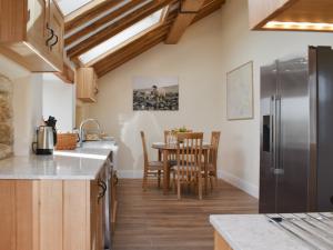 a kitchen with wooden cabinets and a table with chairs at Tormire Laithe in Bell Busk