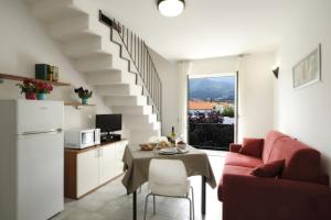 een woonkamer met een tafel en een rode bank bij Residence i Cormorani in Loano