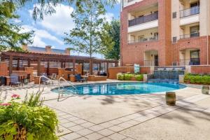 a swimming pool in front of a building at Cozysuites Lovely 1BR Prairie Crossing Apartment 6 in Farmers Branch