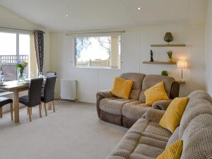 ein Wohnzimmer mit einem Sofa und einem Tisch in der Unterkunft Ocean Glade - Uk32963 in Corton