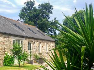 an old stone building with plants in front of it at The Stable in Crowan