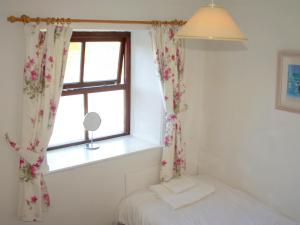 a bedroom with a bed and a window at Sevenstones in Trevilley