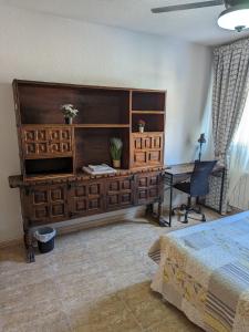 a bedroom with a bed and a desk and a table at Vivienda compartida con ambiente familiar in Seseña