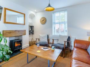 a living room with a table and a fireplace at Tyr Llyr in Penclawdd