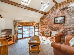 a living room with a brick wall at The Hay Loft in Poulton le Fylde