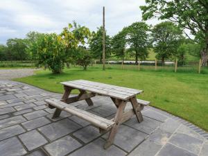 a wooden picnic table sitting on a brick patio at Gelli Hir in Bronant