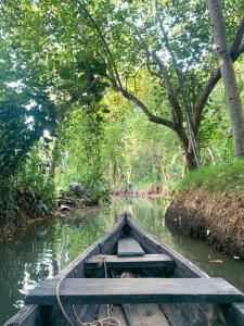 a wooden boat in the middle of a river at Munroeisland Backwaters Homestay in Munroe Island
