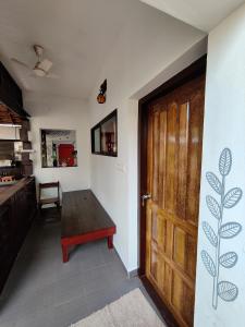 una camera con porta in legno e tavolo di Munroeisland Backwaters Homestay a Munroe Island