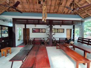 a room with wooden benches and tables in it at Munroeisland Backwaters Homestay in Munroe Island