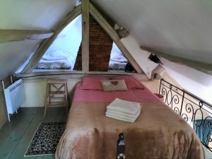 una camera da letto con un letto grande in una mansarda di Gîte des Cornettes a Écardenville-sur-Eure