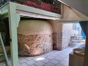 una habitación con un gran horno de pizza en un edificio en Charmante maisonnette en pierre en Écardenville-sur-Eure