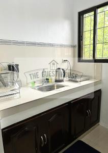 a kitchen with a sink and a sign that reads the guest house at The Guest House in Lucena