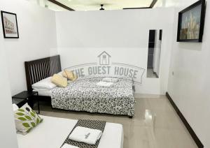 a guest house room with a bed and a couch at The Guest House in Lucena