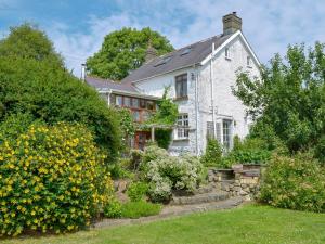 uma casa branca com um jardim em frente em Lordship Farmhouse em Saint Lawrence