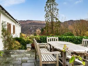 a wooden table and chairs sitting on a patio at Over Brandelhow in Borrowdale