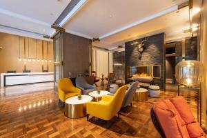 a living room with yellow furniture and a fireplace at Echarm Plus Hotel - Ouzhuang Metro Station Branch in Guangzhou