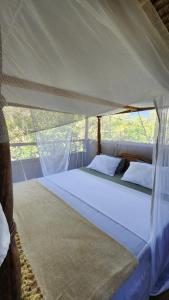 sypialnia z dużym łóżkiem w namiocie w obiekcie Mahali Maalum Barefoot Lodge w mieście Mkwaja