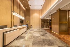 an office lobby with a large tile floor at Echarm Plus Hotel - Ouzhuang Metro Station Branch in Guangzhou