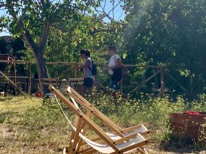2 enfants marchant au-dessus d'une clôture en bois avec des chaises dans l'établissement Casa Cerboneschi, à Casale Marittimo