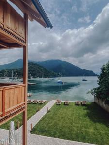 Blick auf einen See mit Stühlen und Booten im Wasser in der Unterkunft Villa Alma - a lakeside Boutique Hotel in Sankt Gilgen