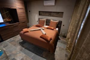 - une chambre avec un grand lit et des oreillers orange dans l'établissement CARACALLA PRIVE - Chambres d'hôtes avec Piscine, Jaccuzi et Hammam privatifs, à Saint-Étienne