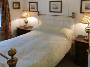 a bedroom with a large bed with two lamps at Inglenook Cottage in Kettlewell