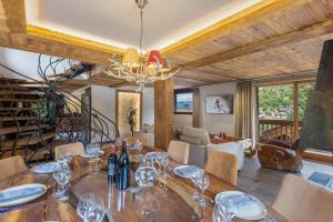 a dining room with a table with wine glasses on it at Le Cheval Blanc Luxe, skis aux pieds, jacuzzi, hammam, salle de cinéma in Les Allues