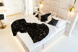 a bedroom with a bed with a black and white blanket at Penthouse apartments MINI s privátnou vírivou vaňou in Trstená